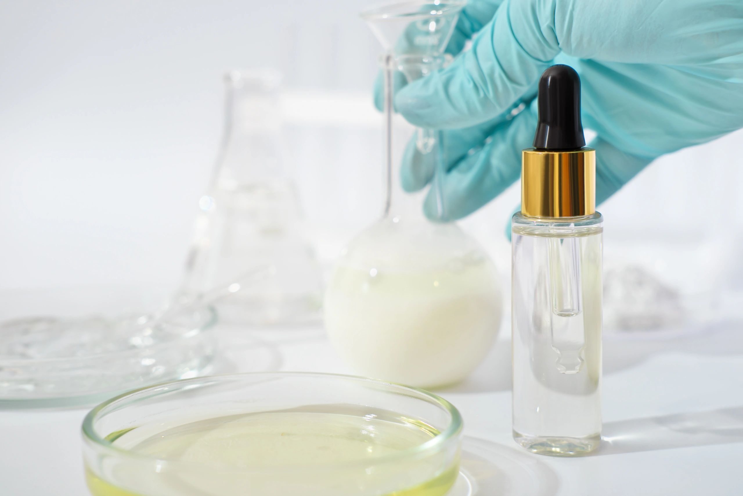 Gloved hand holding lab vial representing safety and compliance checks